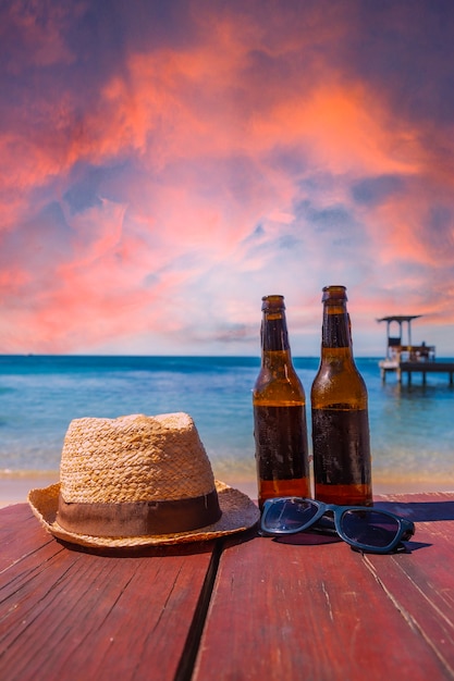 Dos cervezas, gafas de sol y un sombrero en la playa de West End en la isla de Roatán