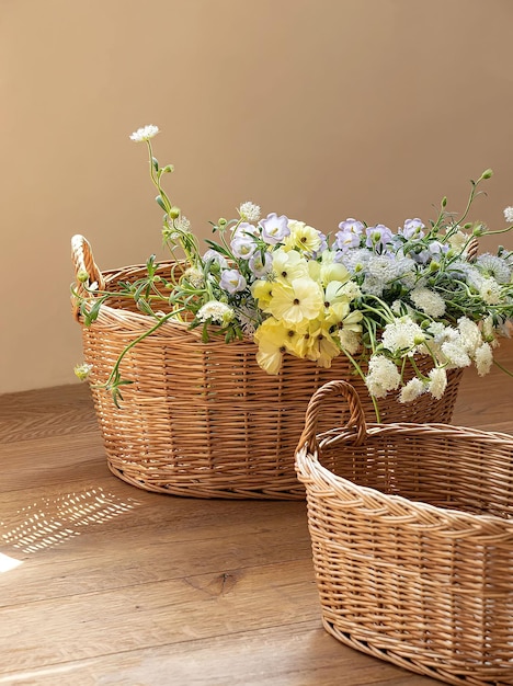 Dos cestas de mimbre con flores sobre una mesa.