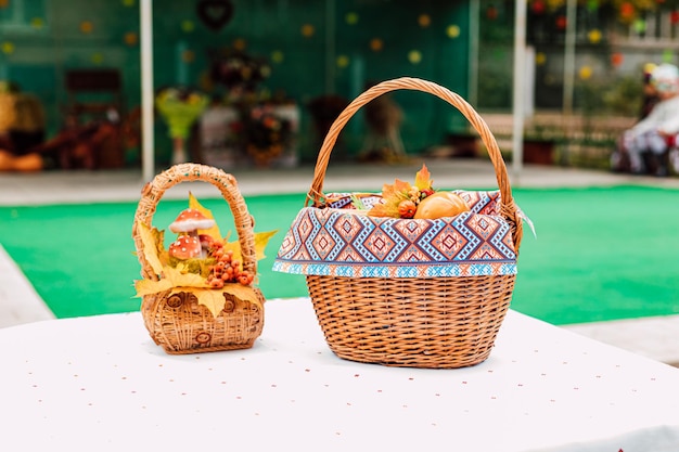 Dos cestas de mimbre hechas de lza de pie sobre la mesa con verduras en la feria