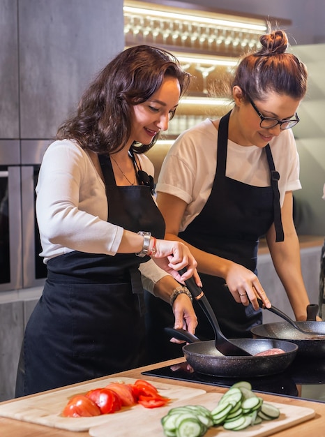 Dos chefs profesionales preparando comida en una cocina grande