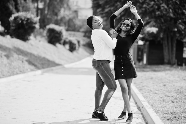 Dos chicas afroamericanas posaron al aire libre en el parche del parque