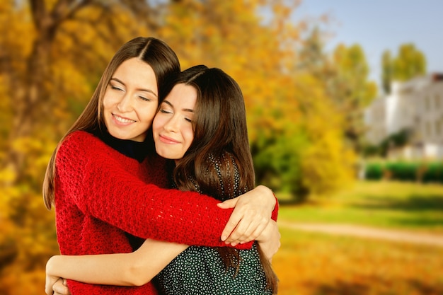 Dos chicas alegres en el parque otoño calle