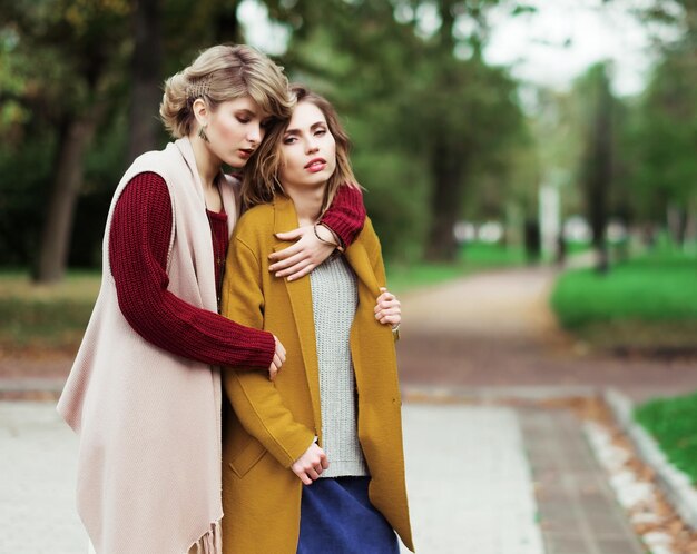 Dos chicas alegres en el parque otoño