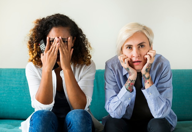 Dos chicas asustadas en el sofá.