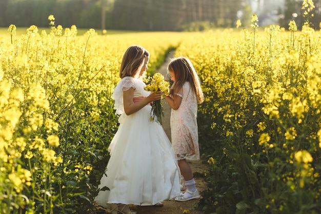 dos chicas en un campo de colza en verano