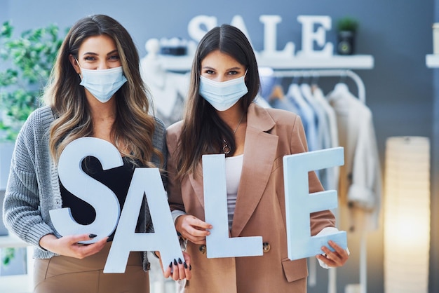 Dos chicas en compras con porcentaje de venta firmar en máscara. Foto de alta calidad