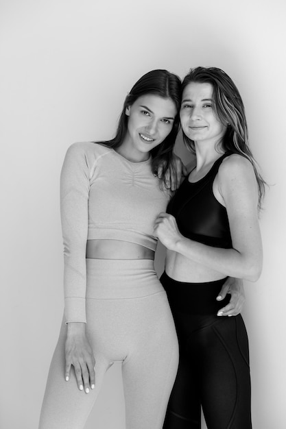 Dos chicas de deportes posando aislado en un fondo blanco modelo de fitness mujer en estudio con espacio de copia ...