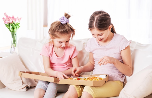 Dos chicas están haciendo pizza