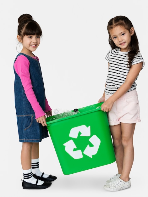 Dos chicas están sosteniendo una papelera de reciclaje