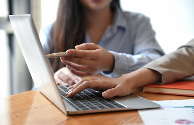 Dos chicas están utilizando una computadora portátil.