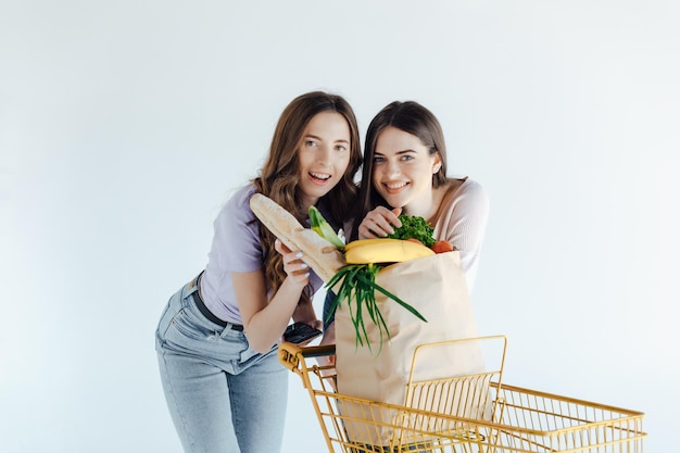 Dos chicas europeas divirtiéndose después de ir de compras. Retrato interior de hermanas extáticas posando juntas.