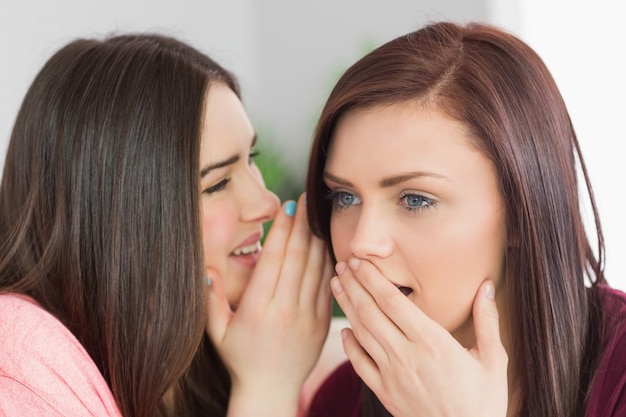 Dos chicas felices compartiendo secretos