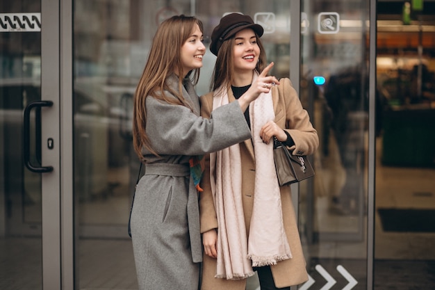 Dos chicas fuera del centro comercial en un día de otoño