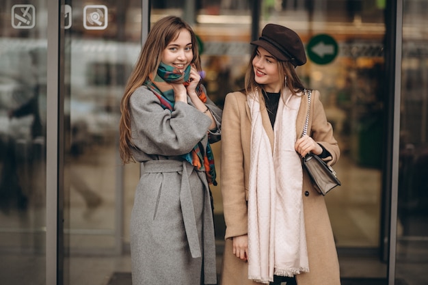 Dos chicas fuera del centro comercial en un día de otoño