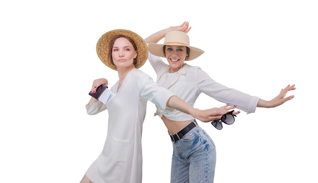 Dos chicas guapas posando sobre un fondo blanco antes de ir de viaje. Concepto de turismo.