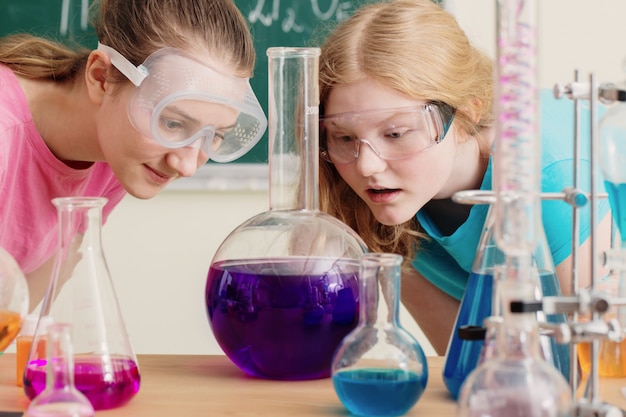 Dos chicas haciendo experimentos químicos en la escuela