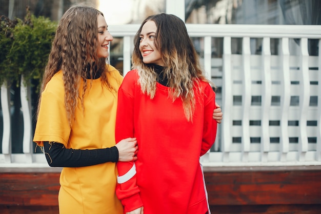 dos chicas hermosas y con estilo en ropa de moda están caminando en la ciudad de primavera