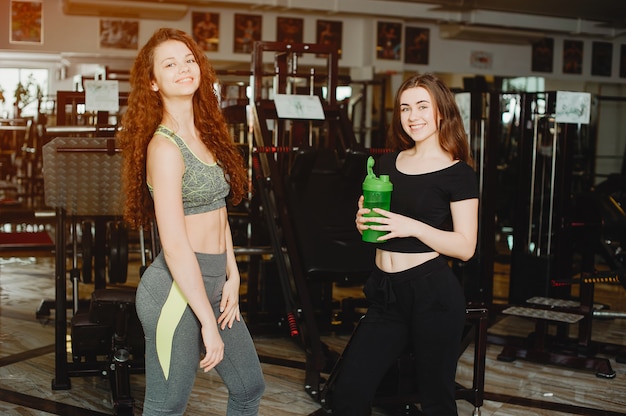 dos chicas jóvenes y atléticas se dedican a los deportes en el gimnasio