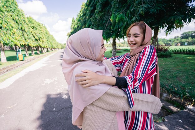 Dos chicas musulmanas se abrazan en la acera