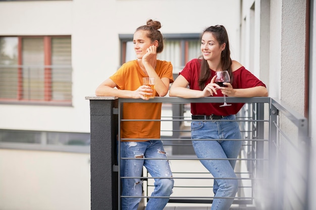 Dos chicas pasan tiempo relajándose en el balcón