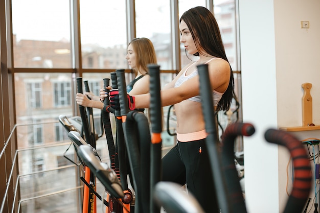 dos chicas de pelo largo deportivo y hermoso entrena en el gimnasio