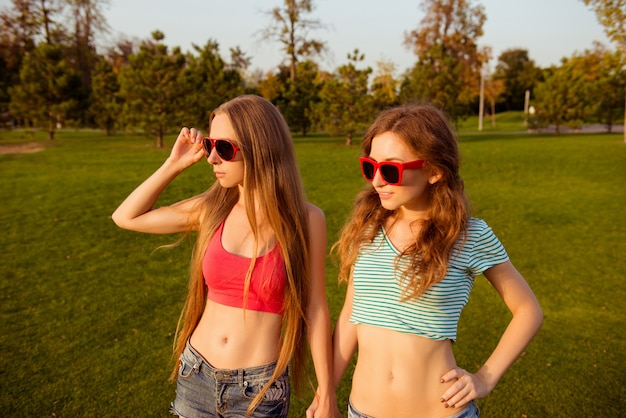 Dos chicas sexy intrigantes mirando la puesta de sol