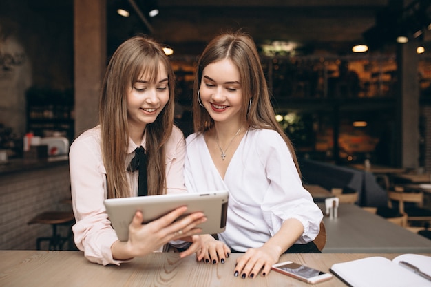 Dos chicas trabajando con tableta en un restaurante