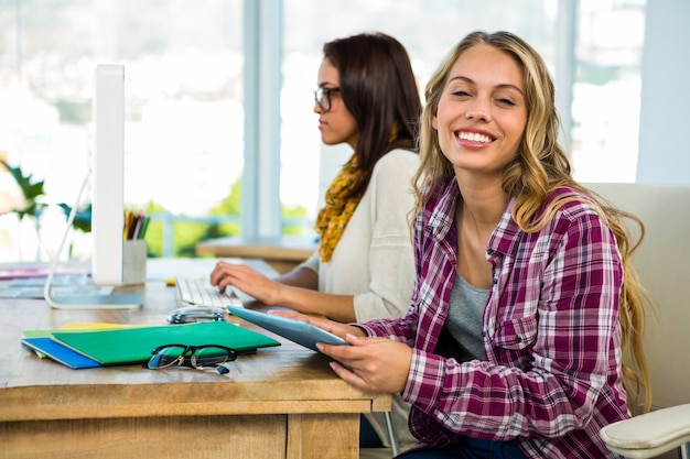 Dos chicas usan una computadora en una oficina