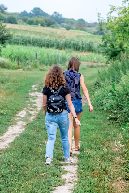 Dos chicas van por un camino de tierra