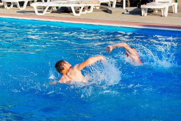 Dos chicos están nadando en la piscina.