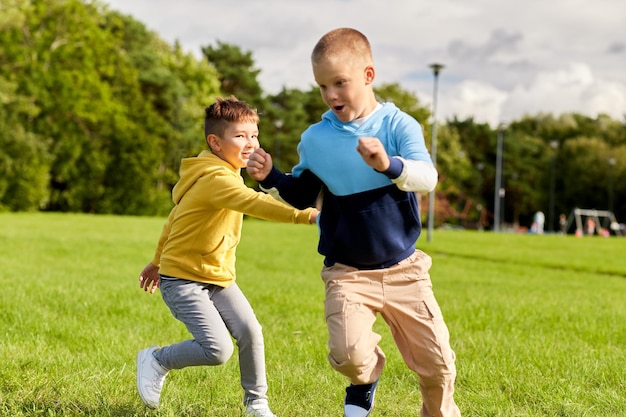 dos chicos felices jugando al juego de la etiqueta en el parque