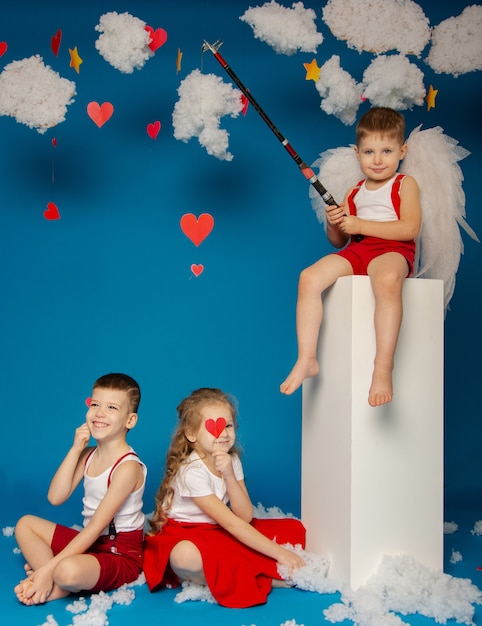 Dos chicos guapos y una niña de ángeles en el día de San Valentín