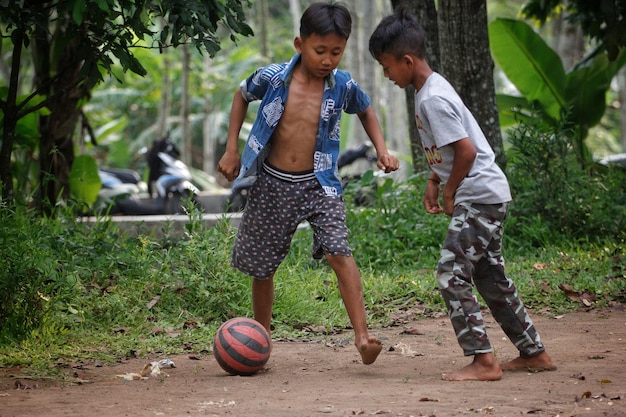 Dos chicos jugando al fútbol con una camisa azul con el número 7 en ella.