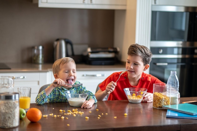 Dos chicos lindos comiendo cereales para el desayuno