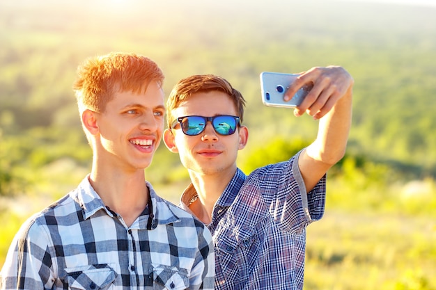 Dos chicos lindos toman selfies amigos felices son fotografiados en el teléfono