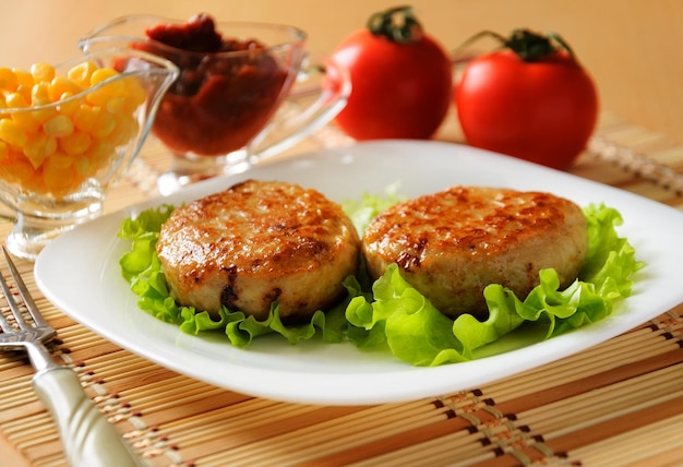 Dos chuletas de pollo en la lechuga de hoja verde