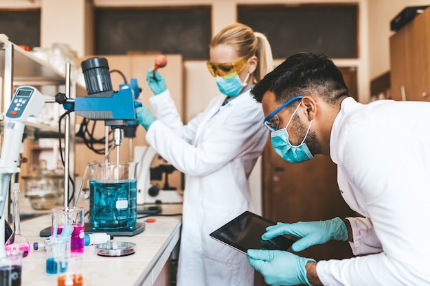 Dos científicos e investigadores de mediana edad trabajan en un laboratorio químico.