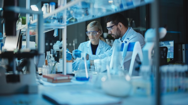 Dos científicos trabajando en un laboratorio, uno de los cuales usa gafas protectoras y el otro usa gafas protectoras.