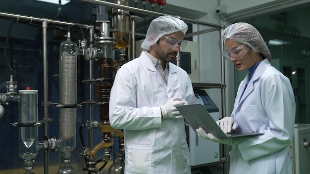 Dos científicos con uniforme profesional trabajando en laboratorio para experimentos químicos y biomédicos