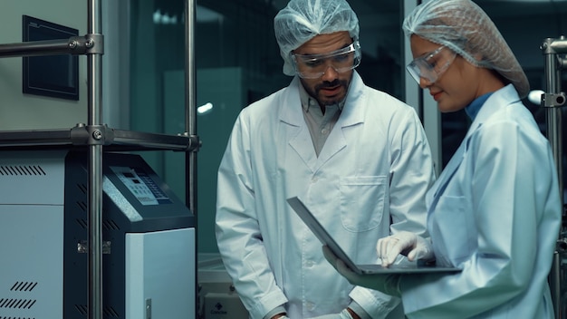 Dos científicos en uniforme profesional trabajando en un laboratorio para experimentos químicos y biomédicos