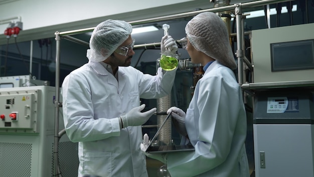 Dos científicos con uniforme profesional trabajando en laboratorio