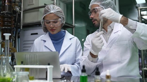 Dos científicos con uniforme profesional trabajando en laboratorio