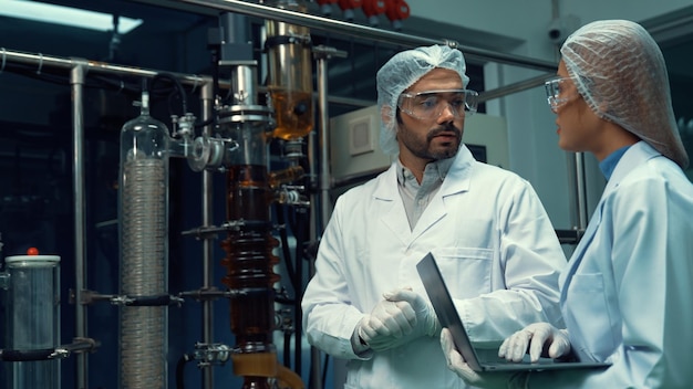 Dos científicos con uniforme profesional trabajando en laboratorio