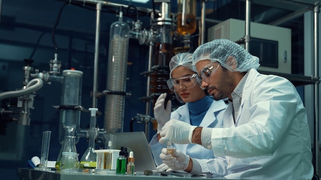 Dos científicos con uniforme profesional trabajando en laboratorio