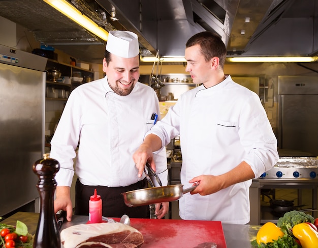 Dos cocineros cocinan juntos