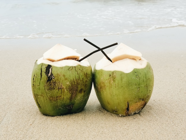 Foto dos cocos con un soporte de tubo en la playa, isla paraíso, tailandia