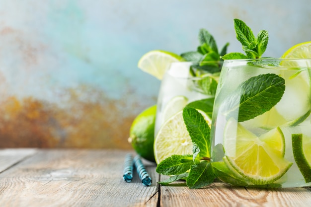 Dos cócteles de mojito con cubitos de hielo en un vaso.