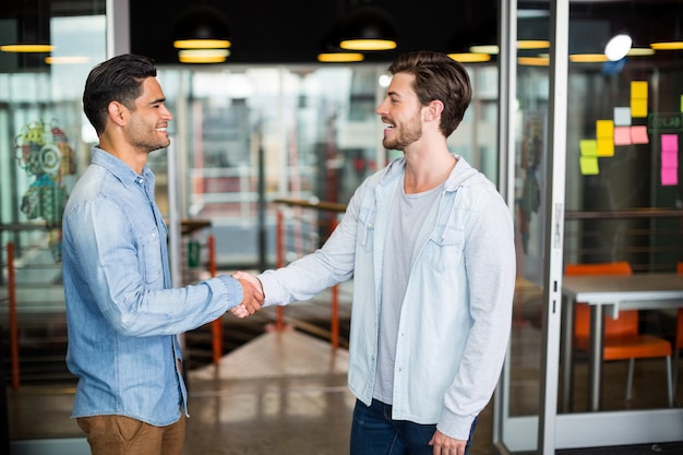 Dos colegas dándose la mano en la oficina