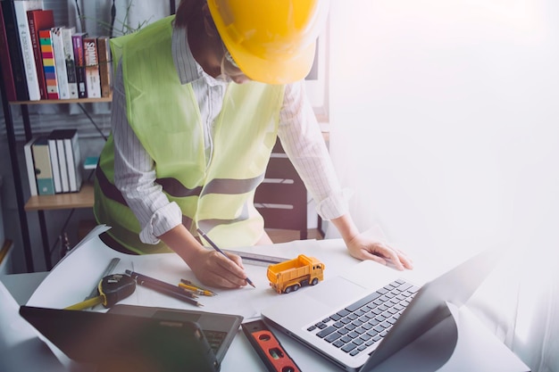 Dos colegas discuten el trabajo de datos y una tableta portátil con un proyecto arquitectónico en el sitio de construcción en el escritorio de la oficina