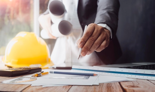 Dos colegas discuten el trabajo de datos y una tableta portátil con un proyecto arquitectónico en el sitio de construcción en el escritorio de la oficina